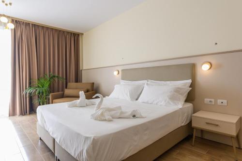a hotel room with a large bed with towels on it at Fllad Resort & SPA Durres in Golem