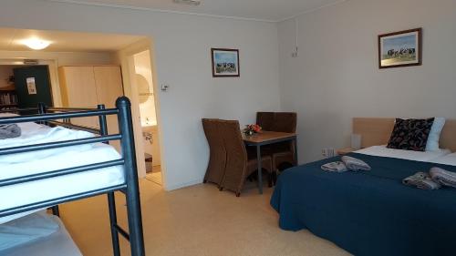 a bedroom with two bunk beds and a table at lodge 61 hotel aan het water in Medemblik