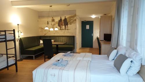 a bedroom with a white bed and a living room at lodge 61 hotel aan het water in Medemblik