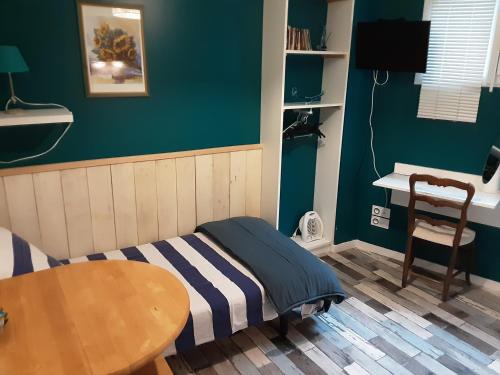 - une petite chambre avec un lit et une table dans l'établissement La Maison du Monde, à Limoges