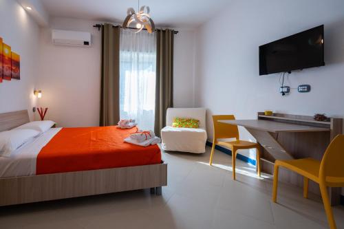 een slaapkamer met een bed, een bureau en een stoel bij SunSea Bed And Breakfast in Agropoli