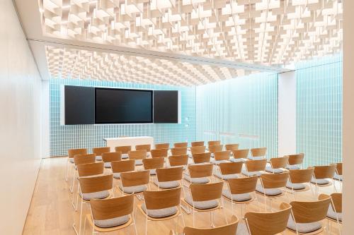 a conference room with chairs and a flat screen tv at Cusanus Akademie - Accademia Cusanus in Bressanone