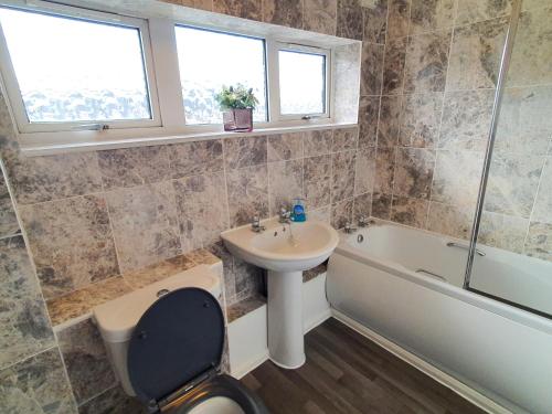 a bathroom with a sink and a toilet and a bath tub at Rabbit Haven - 4 minutes from Bicester Village! in Bicester