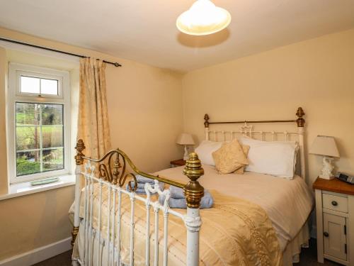 una camera da letto con un letto e una finestra di Smithy Cottage at Bowland Bridge a Bowland Bridge