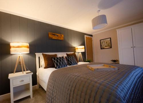 a bedroom with a large bed with two lamps at Hollicarrs - The Rushes in Riccall