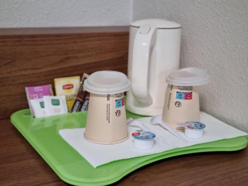 a green tray with two coffee cups on it at Campanile Toulouse - Blagnac Aéroport in Blagnac