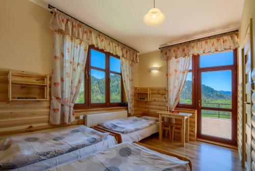 a bedroom with two beds and a window at Schronisko PTTK Trzy Korony in Sromowce Niżne