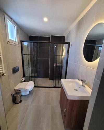 a bathroom with a shower and a toilet and a sink at BEGONVİL VİLLA in Belek