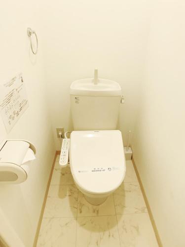 a bathroom with a toilet with a remote control at OUCHI HOTEL Fujimi in Hiroshima