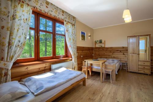 a room with two beds and a table in it at Schronisko PTTK Trzy Korony in Sromowce Niżne