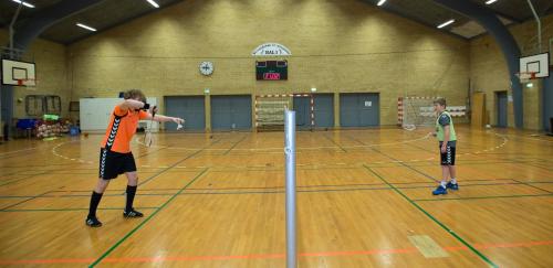 two boys playing a game of volleyball in a gym at SportsPark Blaavandshuk Resort in Oksbøl