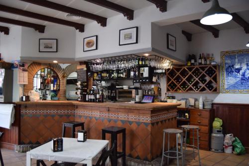 eine Bar in einem Restaurant mit einer Theke und Stühlen in der Unterkunft Pensión San Marcos in Arcos de la Frontera