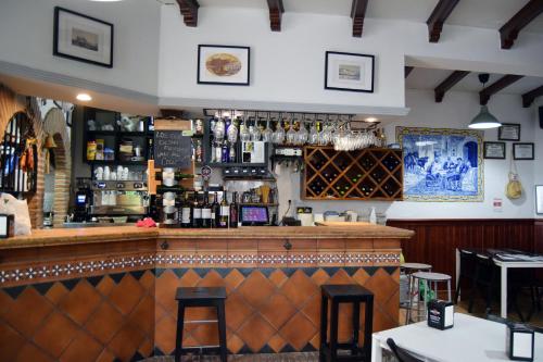 a bar in a restaurant with a counter and stools at Pensión San Marcos in Arcos de la Frontera