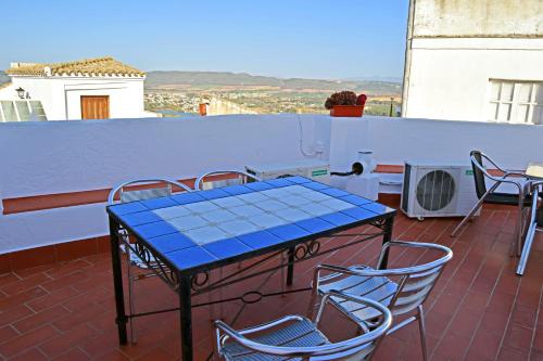 a blue table and chairs on a balcony at Pensión San Marcos in Arcos de la Frontera