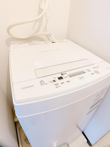 a white washing machine with a toilet seat on top at OUCHI HOTEL Fujimi in Hiroshima