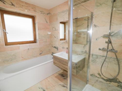 y baño con bañera, lavamanos y ducha. en House Crohy Head, en Dungloe