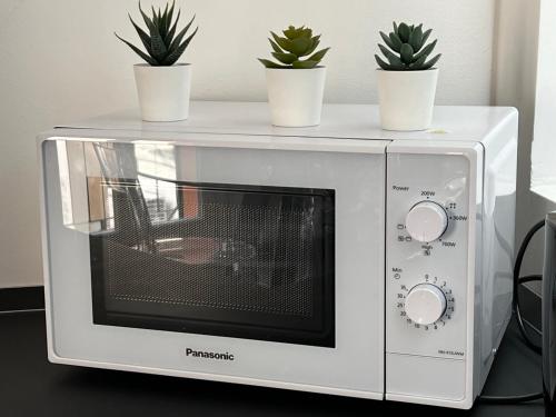 a microwave with potted plants on top of it at Blue Diamond Como in Como