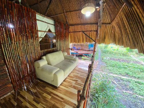 a couch sitting inside of a thatch hut at Saigon Garden Homestay in Ho Chi Minh City