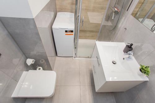 Urban Jungle - Space Apartment في بياويستوك: حمام مع حوض ومرحاض ودش