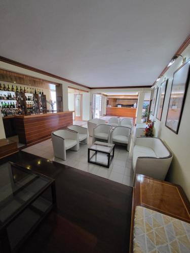 a room with couches and tables and a bar at Hotel Beira Mar in Angra do Heroísmo