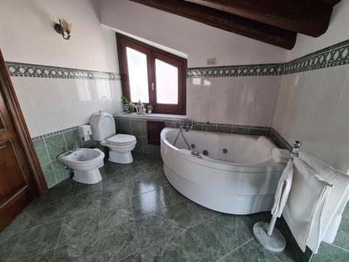 a bathroom with a tub and a toilet and a sink at VILLA PANORAMICA DELL'ETNA in SantʼAlfio