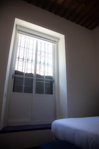 a bedroom with a door with a window and a bed at Noches en Triana in Seville