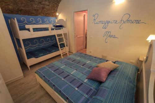 Rifugio dei Pescatori في ريوماجّوري: غرفة نوم مع سرير وسريرين بطابقين