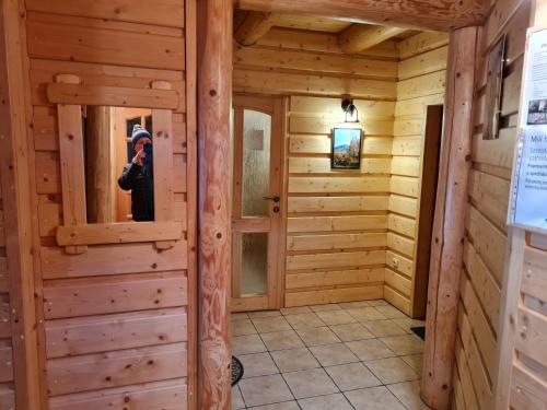 una persona che scatta una foto di una camera in legno in una baita di tronchi di Penzión Malá Fatra u Ďurka a Žilina