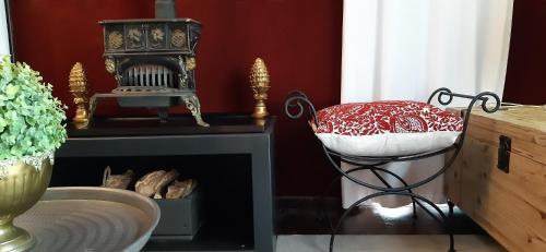 a room with a chair and a table with a clock at Furrows Lodge in Nieu-Bethesda