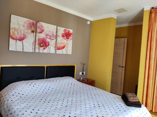 een slaapkamer met een bed met twee schilderijen aan de muur bij Casa Pepe in Ciutadella