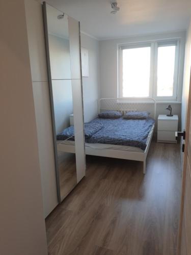 sypialnia z łóżkiem i dużym lustrem w obiekcie Mieszkanie z widokiem na morze w Gdańsku