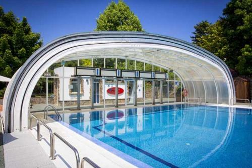 a large swimming pool with an arch over it at Apartamentos Pazo do Rio in A Coruña