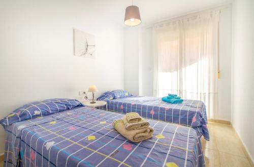 a bedroom with two beds with a towel on it at La Manga 14 in San Javier
