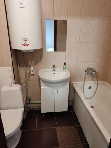 ein Badezimmer mit einem Waschbecken, einem WC und einer Badewanne in der Unterkunft проспект Миру 35 in Krywyj Rih