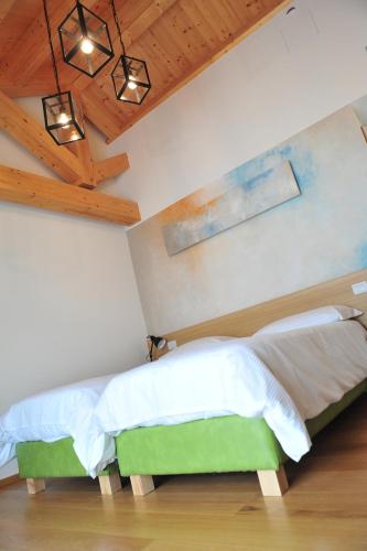 a bedroom with a bed with a wooden ceiling at NUOVA FILANDA Rooms and More in Valdobbiadene