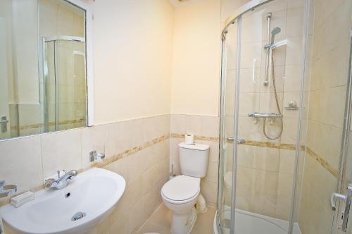 a bathroom with a toilet and a sink and a shower at Leigh House Hotel in London