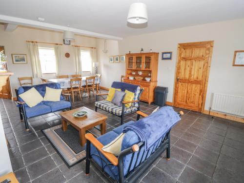 a living room with blue chairs and a table at 8 Lios Na Sioga in Belmullet