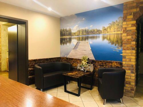 a room with a painting of a dock on the wall at Villa Skomanda in Augustów