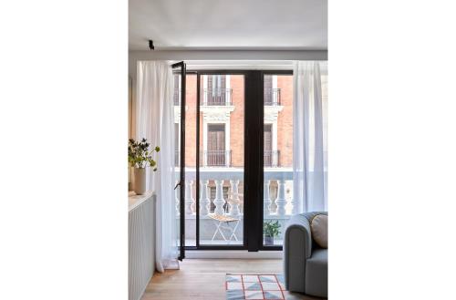 a living room with a sliding glass door with a view at 60 Balconies Iconic in Madrid