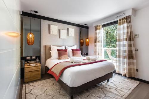 a bedroom with a large bed and a window at Villa Alexandra by Sweett in Cannes