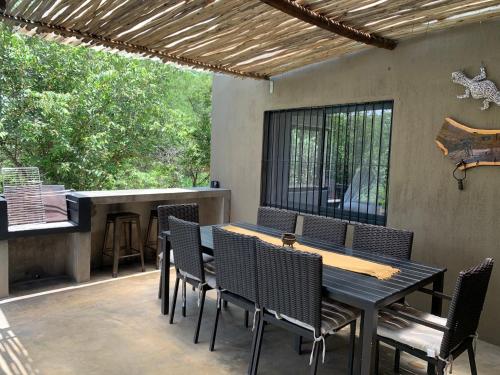 a patio with a wooden table and chairs at Kruger Willows in Marloth Park