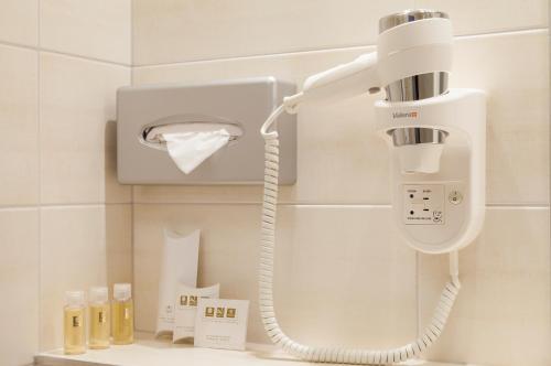 a hair dryer and a phone in a bathroom at Comfort Hotel Lille L'Union in Tourcoing