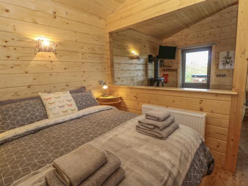 um quarto com uma cama num chalé de madeira em Foxes Den em Darlington