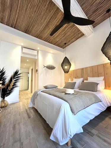 a bedroom with a large bed and a wooden ceiling at Le S in Argelès-sur-Mer