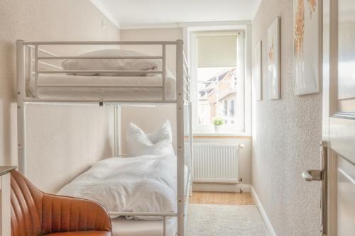 クヴェードリンブルクにあるFerienwohnungen Ziesing am Schlossbergのベッドルーム1室(白いシーツが備わる二段ベッド1組付)