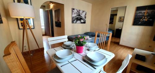 - un salon avec une table blanche et des fleurs dans l'établissement Welcome to Paris, à Ivry-sur-Seine