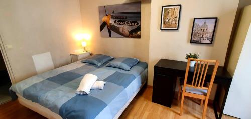 a bedroom with a bed and a desk and a chair at Welcome to Paris in Ivry-sur-Seine