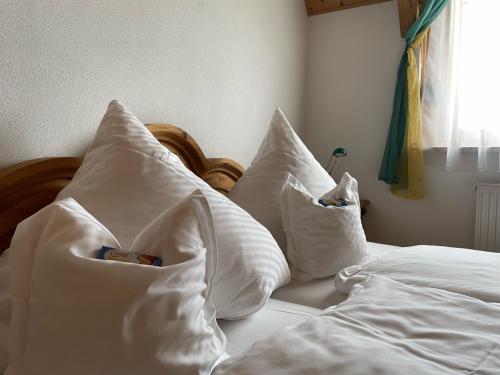a bed with white pillows on top of it at Ferienwohnungen Am Kirchberg Kapplblick in Neualbenreuth