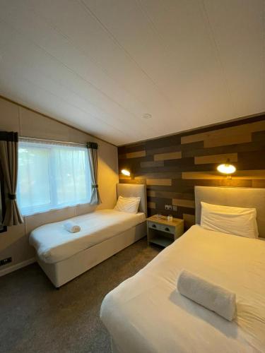 Habitación de hotel con 2 camas y ventana en Eastgate Lodge with Hot Tub, en Malton