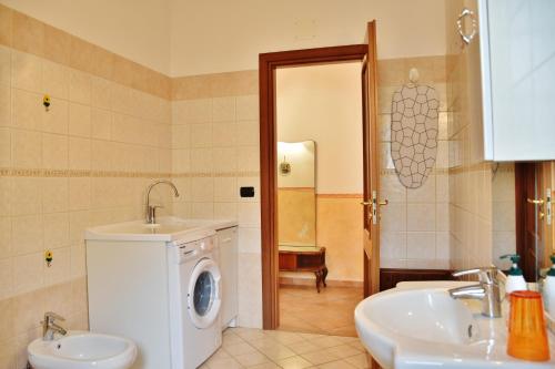 a bathroom with a washing machine and a sink at Appartamento Girasole in Santa Domenica